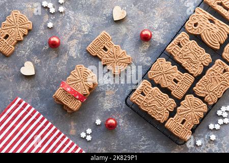 Speculoos or Spekulatius, Christmas biscuits, chocolate balls and stripy towel on dark textured background. Traditional German sweets, cookies for Stock Photo