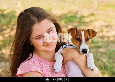 Cute kid hugging Jack Russel terrier puppy Stock Photo