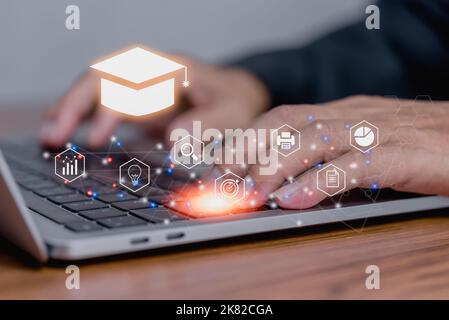 Businessman using laptop computer icon virtual screen education online and e learning on desk. Stock Photo
