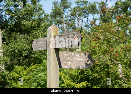 Close up wooden public footpath signpost sign to Friars Crag and Keswick for walkers walk near Derwentwater summer Lake District Cumbria UK England Stock Photo