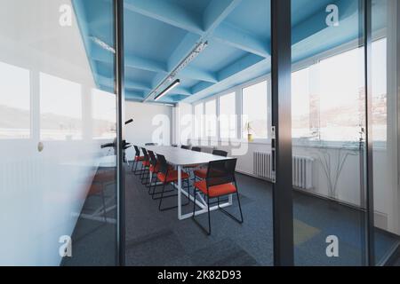 Interior of cozy light boardroom with table, modern stylish chairs and desktop computer, all ready for corporate meeting. Empty spacious office of Stock Photo