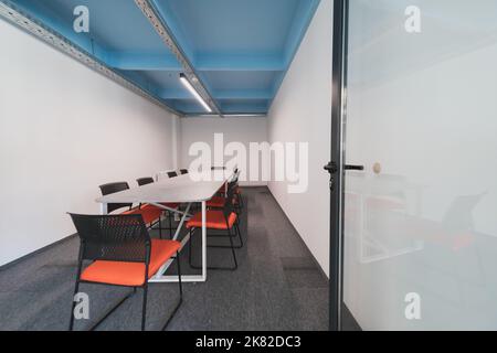 Interior of cozy light boardroom with table, modern stylish chairs and desktop computer, all ready for corporate meeting. Empty spacious office of Stock Photo