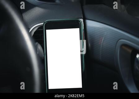 Mobile phone on the car air vent.Blank with white screen.Mock up smart phone in car. Stock Photo