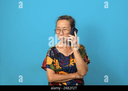 Elderly woman using mobile smartphone technology communications on background. Stock Photo