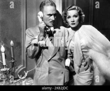John Halliday & Marlene Dietrich Film: Desire (USA 1936) Characters: Carlos Margoli, Madeleine de Beaupre  / Titel Auch: 'Perlen Zum Glück' Director: Frank Borzage 02 April 1936   **WARNING** This Photograph is for editorial use only and is the copyright of PARAMOUNT and/or the Photographer assigned by the Film or Production Company and can only be reproduced by publications in conjunction with the promotion of the above Film. A Mandatory Credit To PARAMOUNT is required. The Photographer should also be credited when known. No commercial use can be granted without written authority from the Fil Stock Photo
