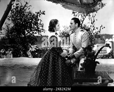 Olivia De Havilland & Errol Flynn Film: The Charge Of The Light Brigade (USA 1936) Characters: Elsa Campbell (as Olivia De Havilland), Major Geoffrey Vickers  / Titel Auch: 'Die Attacke Der Leichten Brigade' Director: Michael Curtiz 20 October 1936   **WARNING** This Photograph is for editorial use only and is the copyright of WARNER BROS. and/or the Photographer assigned by the Film or Production Company and can only be reproduced by publications in conjunction with the promotion of the above Film. A Mandatory Credit To WARNER BROS. is required. The Photographer should also be credited when k Stock Photo