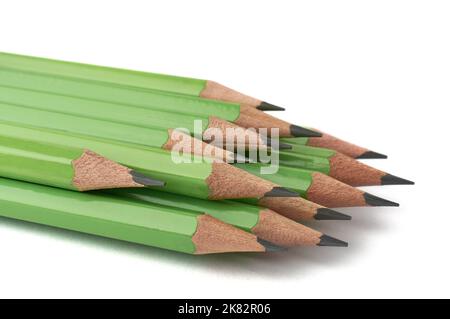 bunch of stacked green color sharpened wooden pencils isolated on white background, close-up in soft-focus Stock Photo