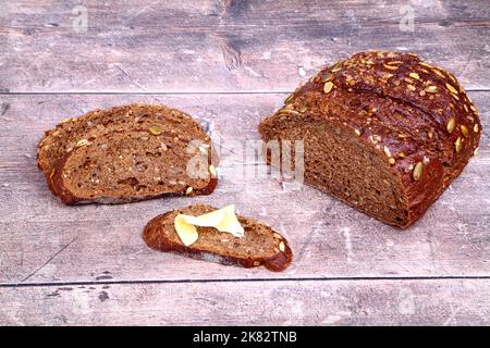 Freshly baked Pumpernickel bread laid on a wood table Stock Photo