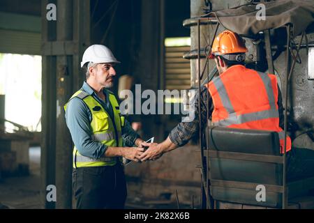 professional technician engineer working to check safety system of heavy industry manufacturing machine in construction plant and service a factory eq Stock Photo