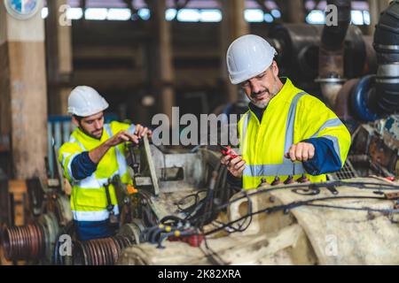 professional technician engineer working to check safety system of heavy industry manufacturing machine in construction plant and service a factory eq Stock Photo
