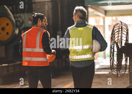 industrial factory with men at work concept, professional engineer foreman inspector talking in business occupation job teamwork with team, constructi Stock Photo