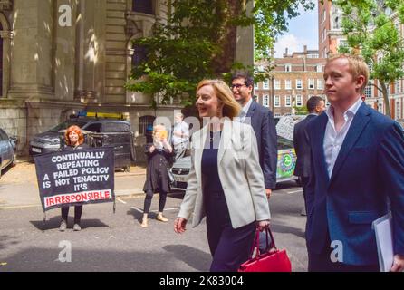 London, UK. 21st July 2022. Liz Truss, Conservative Party leadership candidate and Foreign Secretary, walks past an anti- badger cull protester as she arrives at Transport House for a hustings event. Stock Photo