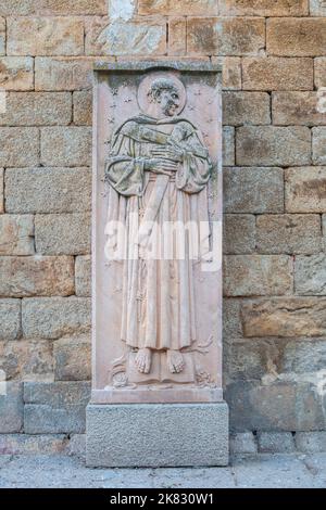 Alcantara, Spain - Oct 6th, 2022: San Pedro de Alcantara relief, Alcantara Caceres, Spain. Jose Navarro Gabaldon sculptor, 1976. Wall of Church of San Stock Photo