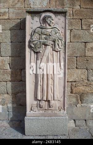 Alcantara, Spain - Oct 6th, 2022: San Pedro de Alcantara relief, Alcantara Caceres, Spain. Jose Navarro Gabaldon sculptor, 1976. Wall of Church of San Stock Photo