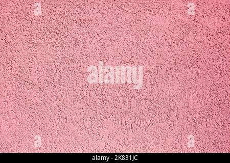 Background of pink concrete wall. Decorative embossed concrete and glue plaster. Pink plastered wall. Plaster textured background. Blurred photo. Stock Photo
