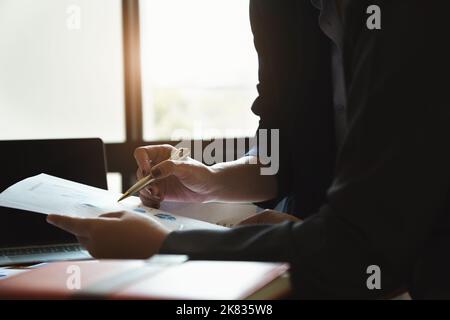 The company employee points to the document to calculate the budget and verify the correctness of the investment. Stock Photo