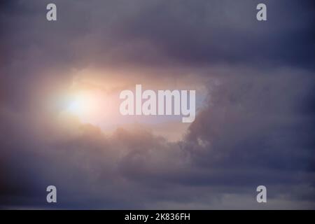Breaking sunlight through gap of storm clouds Stock Photo