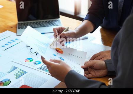 The company employee points to the document to calculate the budget and verify the correctness of the investment. Stock Photo