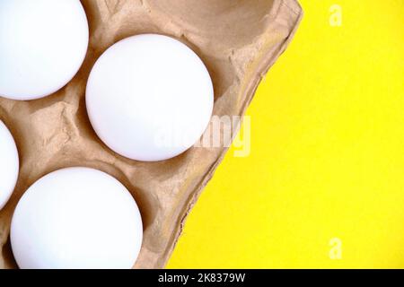 Chicken white eggs in tray on yellow background Stock Photo