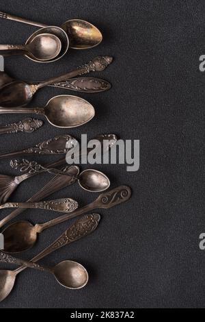 Top view of vintage silver spoons or silverware on dark concrete background Stock Photo