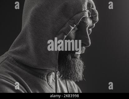 man with hood on a dark background depression or hacker Stock Photo