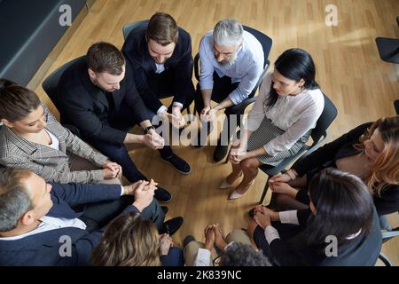 Business people in circle talking during informal brainstorming session or during business training. Stock Photo