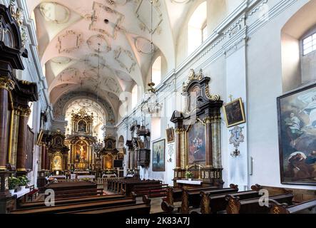 Pinczow, Poland - July 15, 2022: Main nave and presbytery of Holy Mary of Mirow sanctuary within Franciscan monastery in historic old town quarter Stock Photo