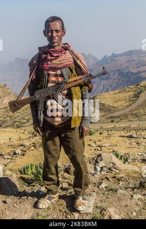 SIMIEN MOUNTAINS, ETHIOPIA - MARCH 17, 2019: Armed scout guarding tourists in Simien mountains, Ethiopia Stock Photo