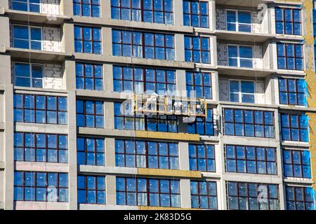 Belarus, Minsk - 20 october, 2022: Builders high-rises on scaffolding on the windows Stock Photo