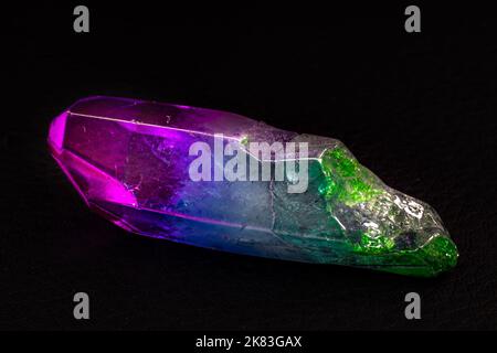 Vibrant colorful Cocktail aura quartz point macro isolated on a black surface. Colorful, pink, blue, white, purple and green man-enhanced Stock Photo