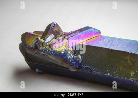 Titanium aura quartz double terminated point with a small cluster, altered natural quartz with strong rainbow color close up on white background. Stock Photo