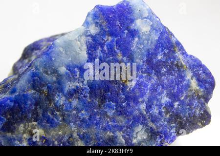 Raw Lapis lazuli rock on white background. Unpolished chunk of lapis lazuli sitting on white background. Lapis lazuli with Pyrite spots . Stock Photo