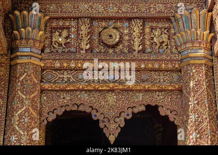 Close-up view of beautiful wooden gable decor of ancient Lanna style viharn or vihara at historic Wat Mahawan buddhist temple, Chiang Mai, Thailand Stock Photo