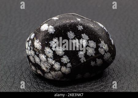 Tumbled close up snowflake obsidian isolated on white background Stock Photo