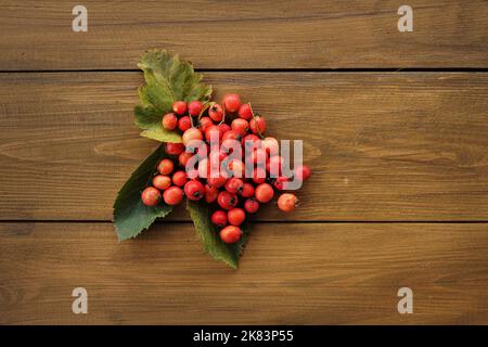 Bright berries of fresh hawthorn on a wooden background.Alternative traditional medicine using hawthorn. Stock Photo