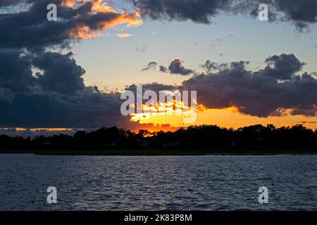 Dramatic sunset at Keyport, New Jersey, with sun setting behind some threatening cumulonimbus clouds -20 Stock Photo