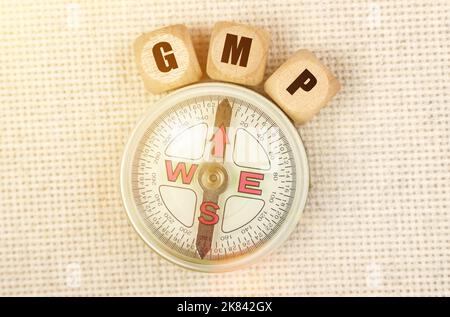 Business concept. On the table is a compass and cubes with the inscription - GMP Stock Photo