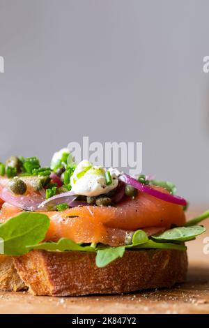 Open sandwich with smoked salmon, pickled onions, sour cream and capers Stock Photo
