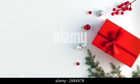 Creative Christmas layout made of natural winter decoration, red gift box and Christmas baubles. Flat lay. Nature New Year concept. Stock Photo