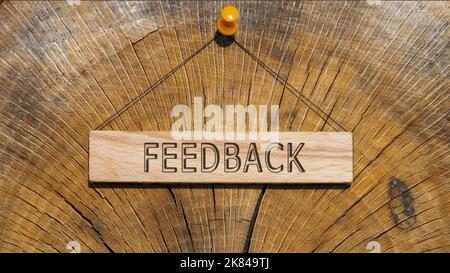 The word feedback is written on the wooden surface. wooden surface in background. Stock Photo