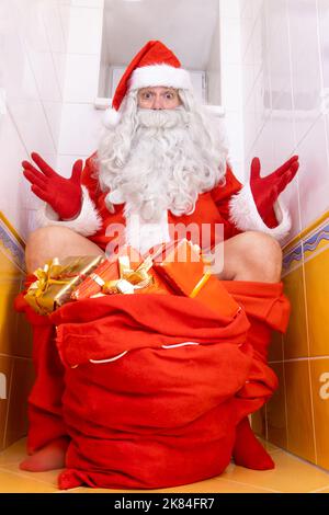 Santa Claus is surprised from the paparazzi photographer when sitting on the toilet Stock Photo