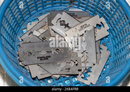 A pile of old razors in a plastic basket Stock Photo