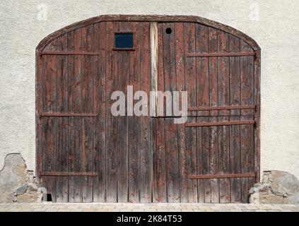 Old large barn door made of weathered brown wood Stock Photo