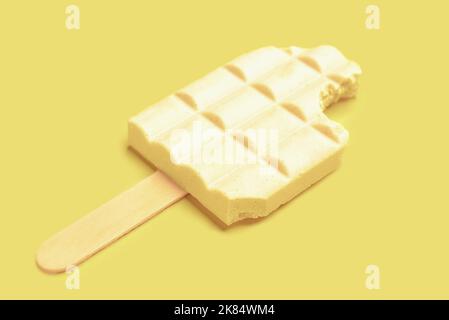 Delicious white chocolate bar and ice cream stick on color background Stock Photo