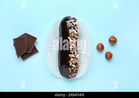 Tasty chocolate eclair on color background Stock Photo