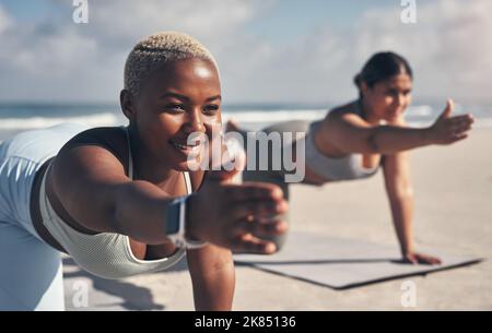 We started our yoga journeys together. two young women practicing yoga on the beach. Stock Photo