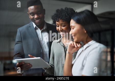 The numbers are looking good. three businesspeople working in a modern office. Stock Photo