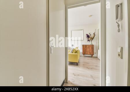 Interior of narrow corridor with telephone and radiator hanging on wall against stairway in daylight Stock Photo