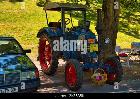 BADEN BADEN, GERMANY - JULY 2022: blue red LANZ BULLDOG retro tractor 1921 1960, oldtimer meeting in Kurpark. Stock Photo