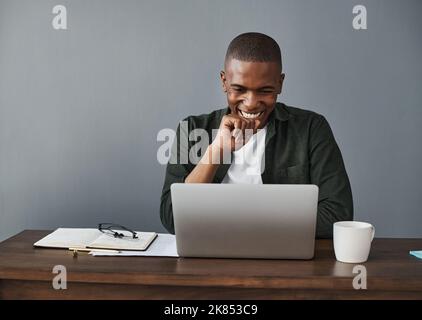 I love working from home. a young businessman using his laptop while working from home. Stock Photo